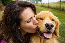 Woman kissing a happy dog